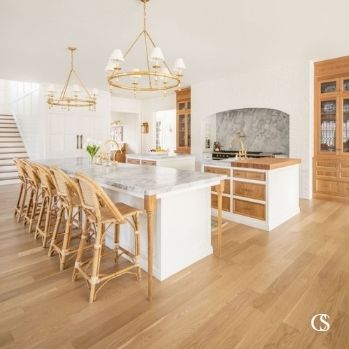 A white kitchen doesn't have to mean anything is stark. This custom kitchen design utilizes warm stained wood to bring life to the kitchen cabinets and completely unique flair to the white and wood kitchen.