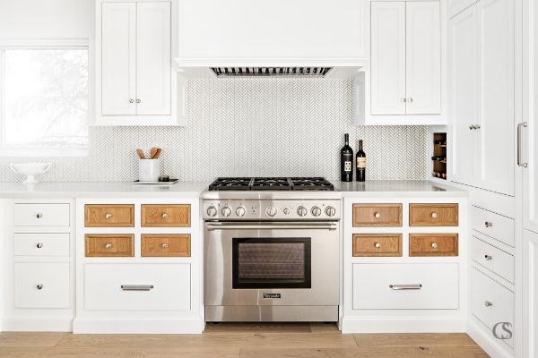 Who says every drawer and cupboard door have to match? These kitchen cabinet doors feature contrasting stained wood against the rest of the white painted cabinets, to great effect!