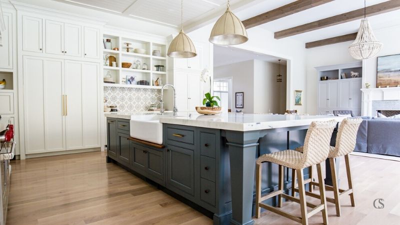 This big custom kitchen island design becomes a focal point of the space but also serves as a separator between kitchen and living rooms. The blue paint color also anchors the entire aesthetic.