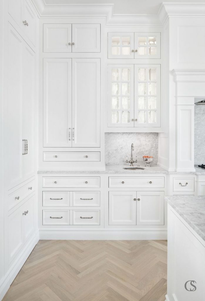 How many different styles of hardware can you spot in this custom cabinet design for the kitchen? Mixing and matching similar drawer pulls and handles is a beautiful way to spice up an all white kitchen.