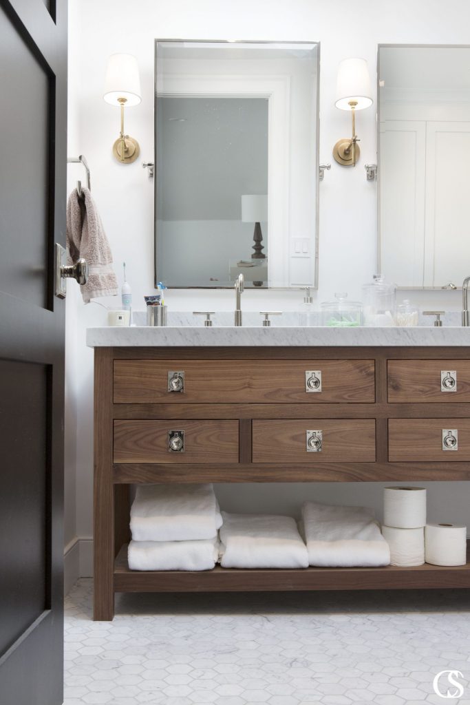 Open shelving can add a fresh look to a bathroom, as long as you keep it clutter-free. Displaying towels, toilet paper (out of the package), bath salts in glass jars, or other functional items can be beautiful in a custom bathroom