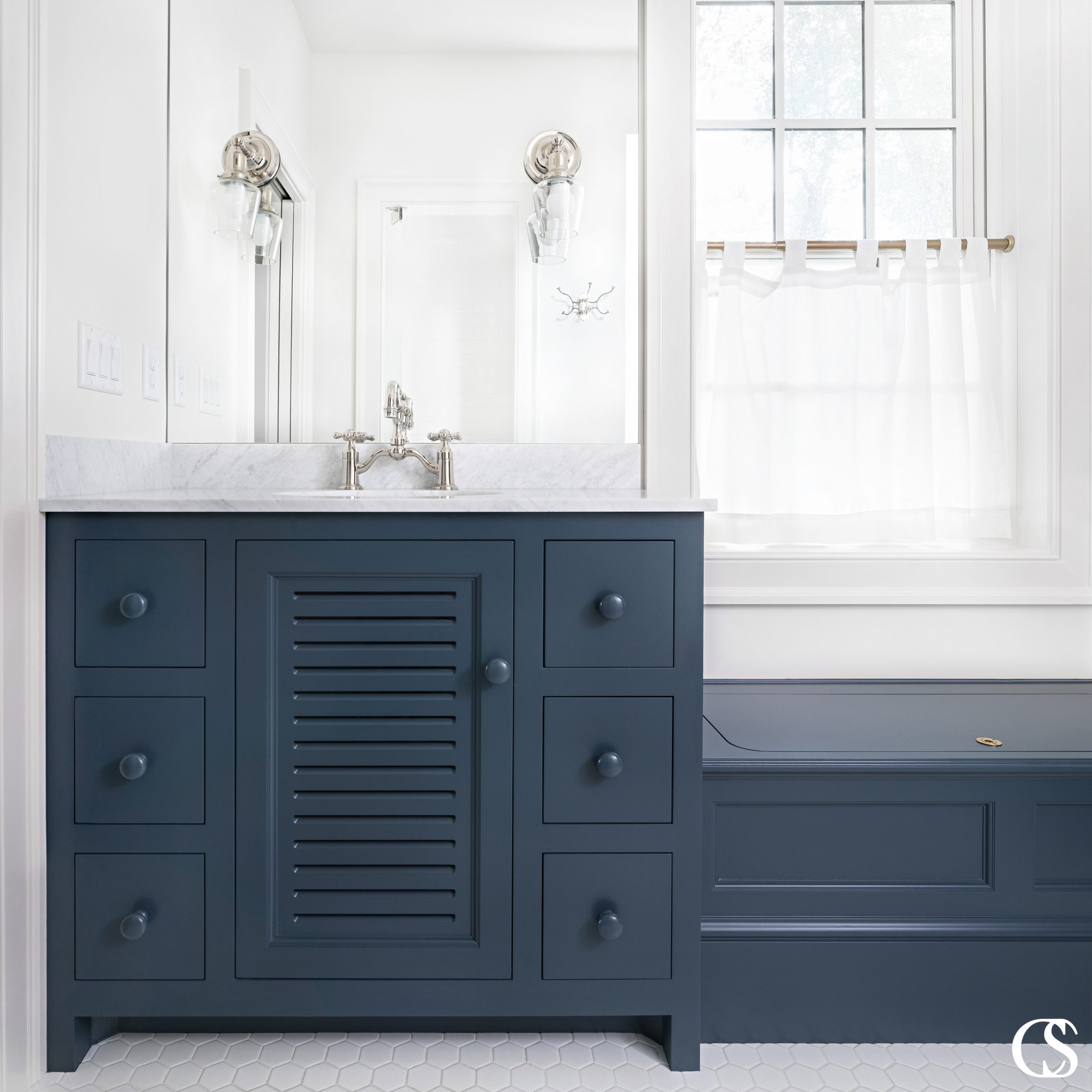 What could become a bulky bathroom cabinets design is completely changed by the slats in the center cupboard door. It's the little decisions like that which take custom cabinetry to the next level.