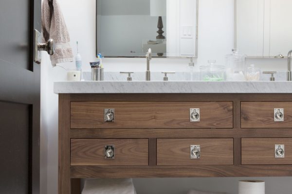 Slab front drawers, distinctive hardware, clean lines...what vanity dreams are made of! This unique custom bathroom cabinet pulls off a look completely different than most bathroom vanities—that's what working with professional cabinet designers will get you.