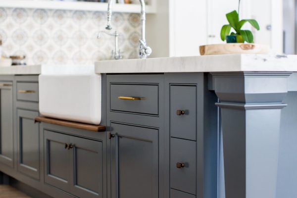 It's amazing how some open kitchen shelves can balance the weight of this blue kitchen island design. It almost creates an anchor for the room so great kitchen lighting and custom wall tile can really pop.