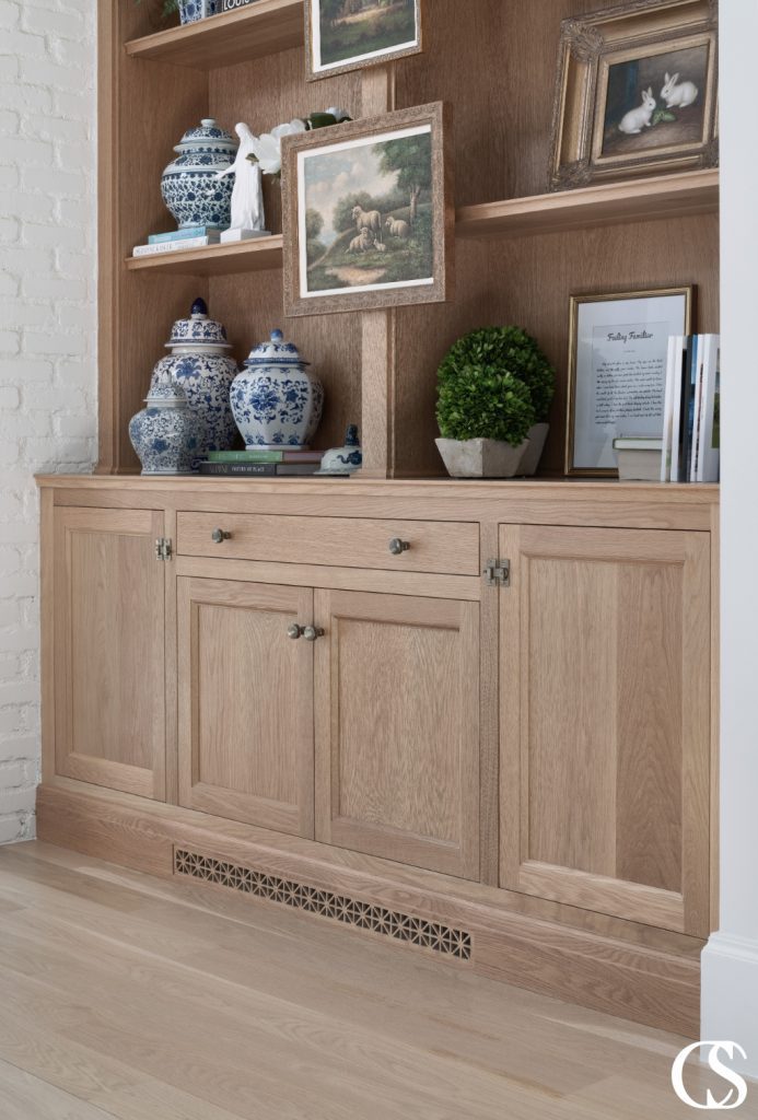 Custom built-in cabinets designed to fit seamlessly into the architecture of the room, featuring a warm wood finish and ample storage space.