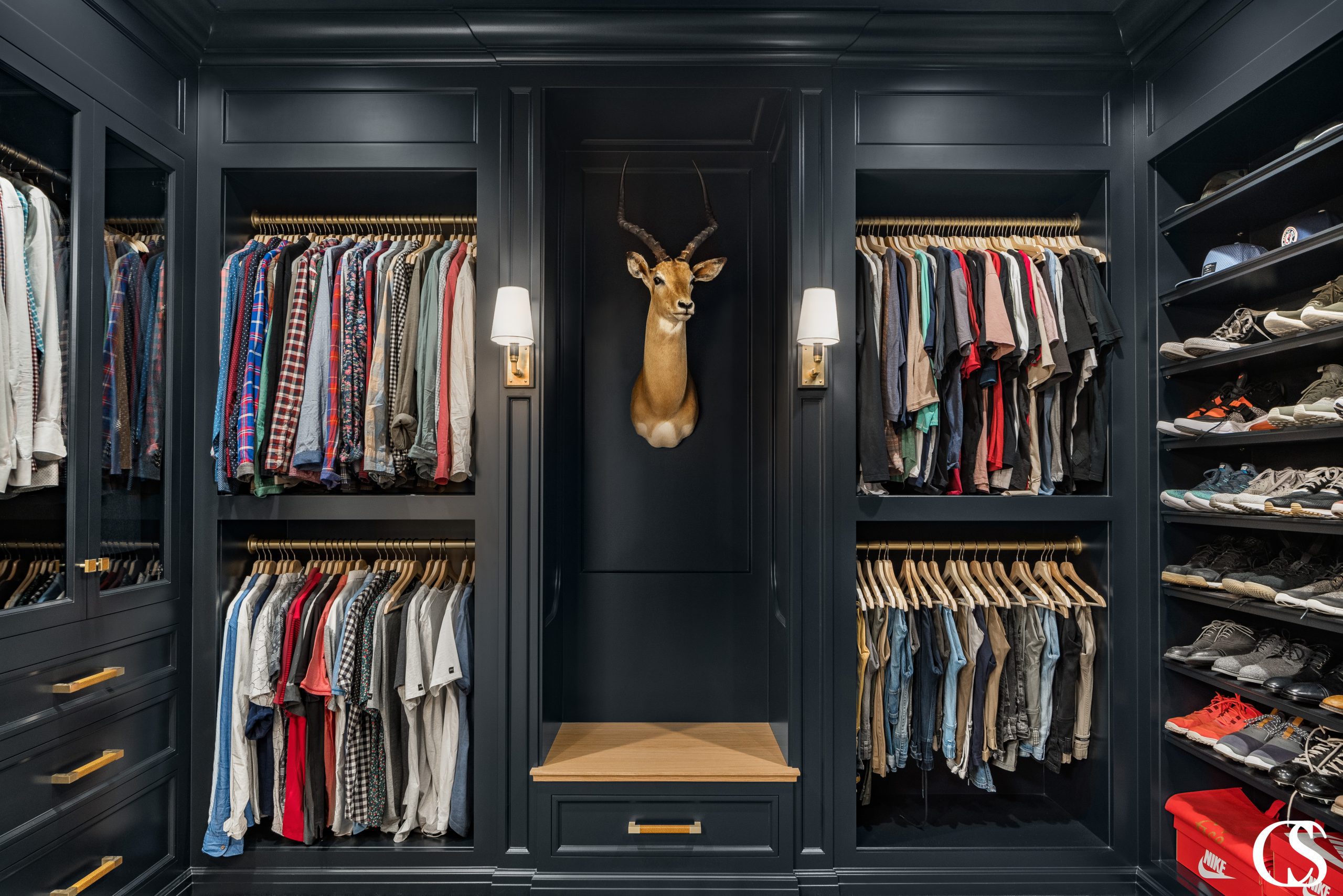 Don't ever think that custom built in cabinet closet design is just for the ladies. This man cave of a dream closet is moody and makes every hat, shirt, and pair of shoes pop.