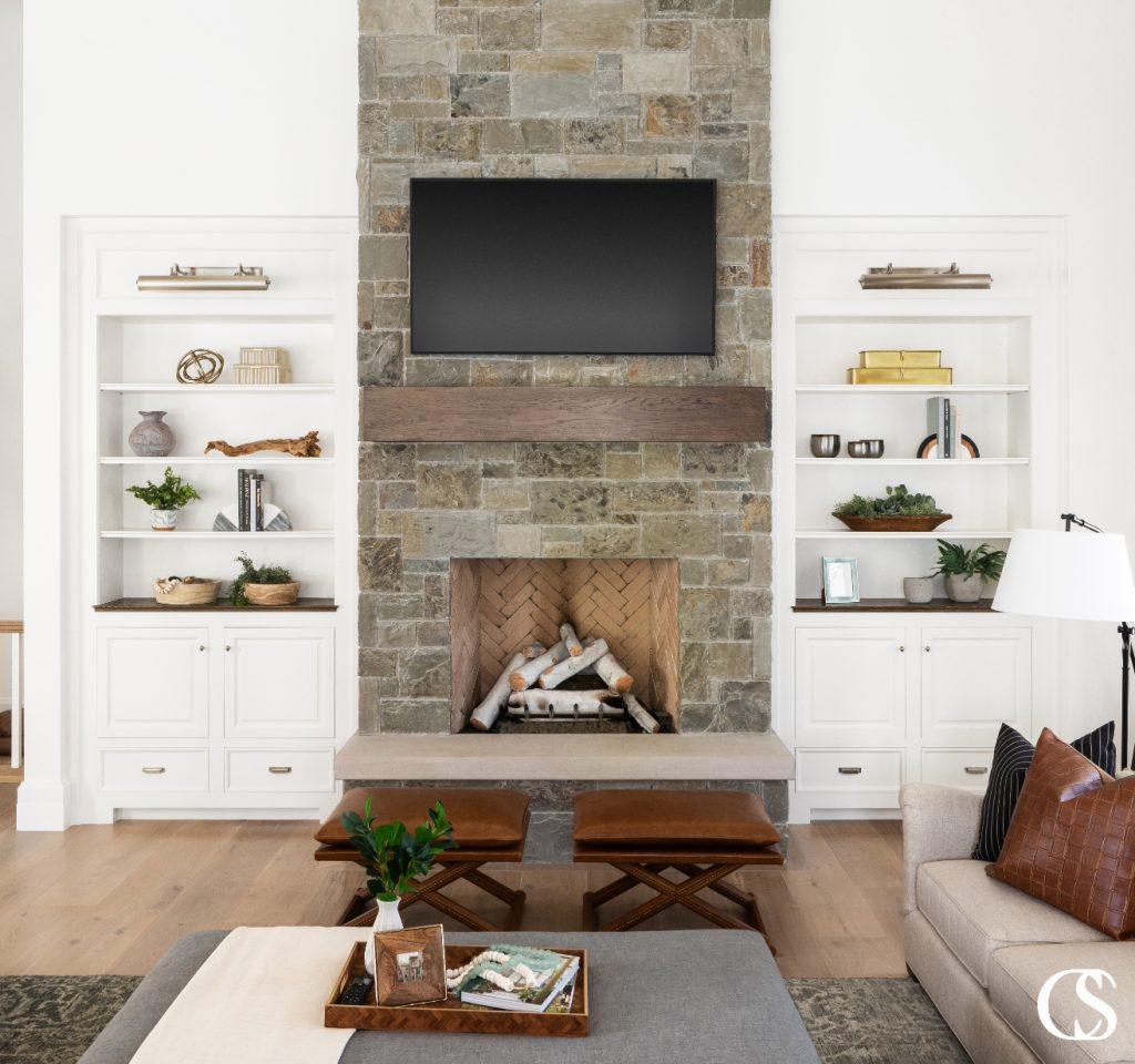 The custom built-in bookshelves and cabinets are the perfect place to store TV accessories, while the shelves are decorated beautifully and do the job of distracting from the giant black rectangle that hangs above the mantle