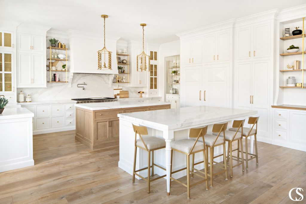 Open shelving, mullioned cupboards, hidden refrigerators, and a double island set up all come together in some of the best custom cabinet design for a kitchen.