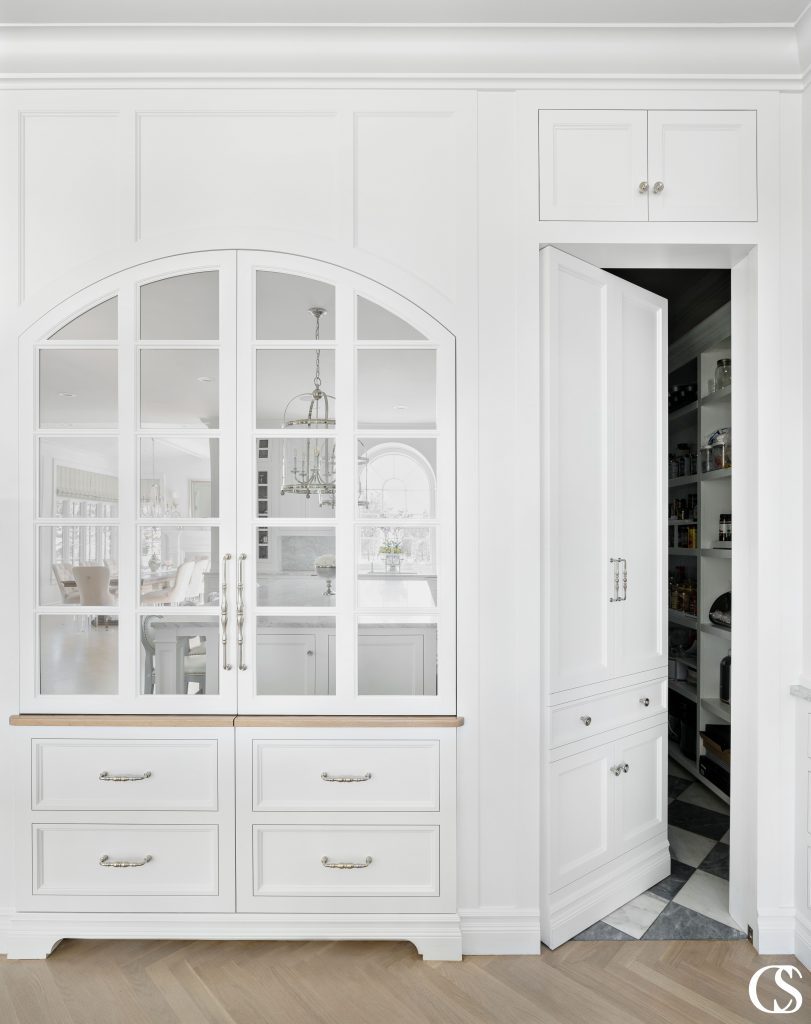 Some of the best custom cabinets designed for the kitchen incorporate pieces that aren't actually cabinets at all—like this "hidden" door to the pantry.