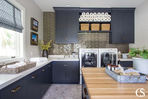 I love this laundry room! One, for its moody take on a household task and two, because it has some of the best design ideas for cabinets in the laundry room—like pull out cabinets for each family members' clothes hamper!