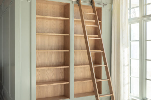 The ladder not only makes the upper shelves accessible in this bookcase, but it becomes a design element itself.