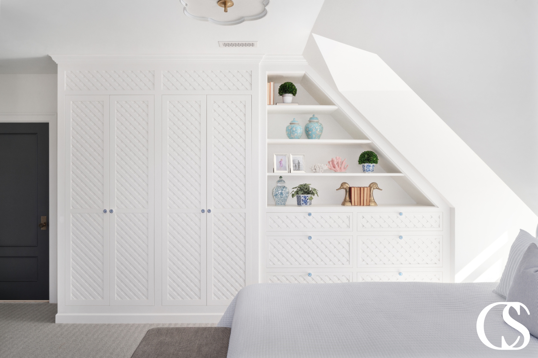Beautiful custom built-in white cabinets designed with a classic, timeless aesthetic featuring elegant crown molding and ample storage space, perfect for a bedroom.
