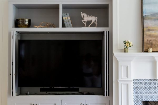 A custom built in entertainment center can be crafted to hide and store your electronics with custom bi-fold cabinet doors like this. Close the doors and you’ve got a beautiful living room.