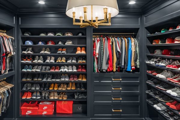 Don't ever think that custom built in cabinet closet design is just for the ladies. This man cave of a dream closet is moody and makes every hat, jacket, and pair of shoes pop.