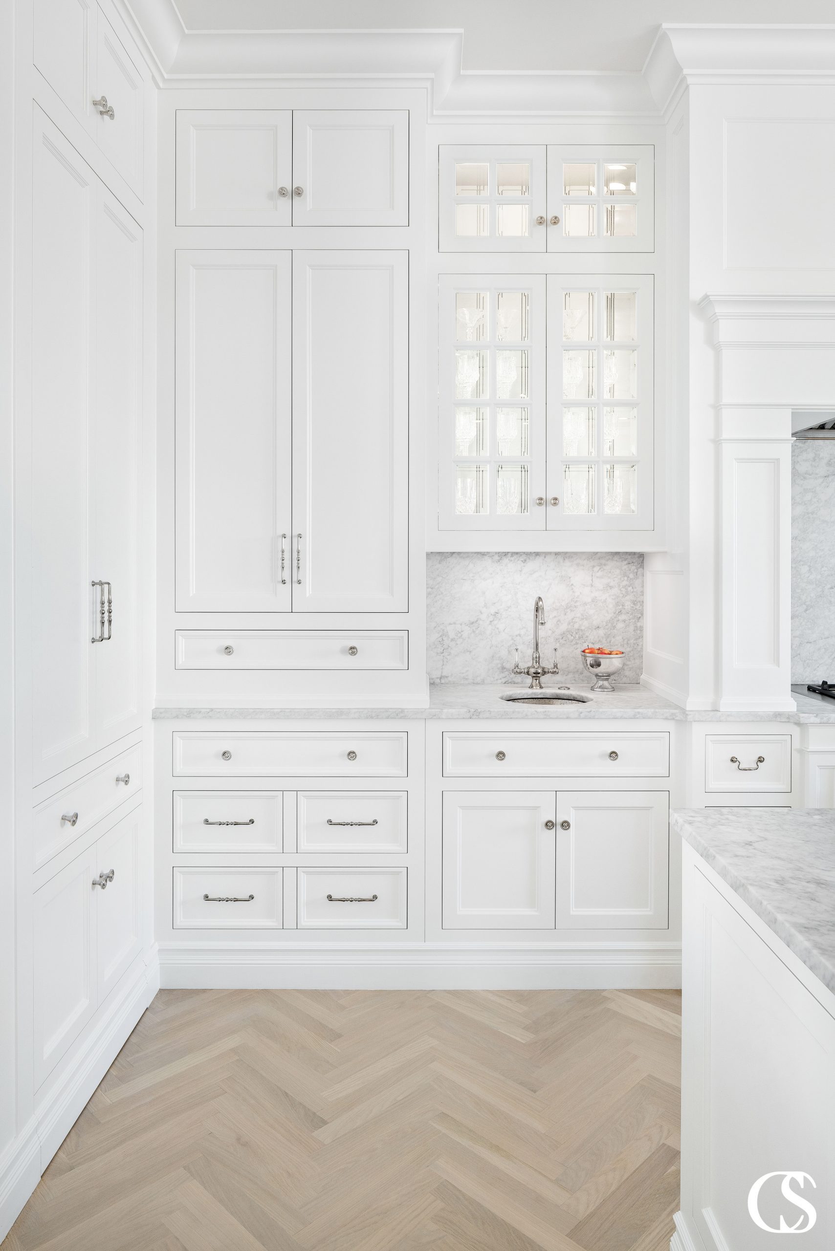 How many different styles of hardware can you spot in this custom cabinet design for the kitchen? Mixing and matching similar drawer pulls and handles is a beautiful way to spice up an all white kitchen.