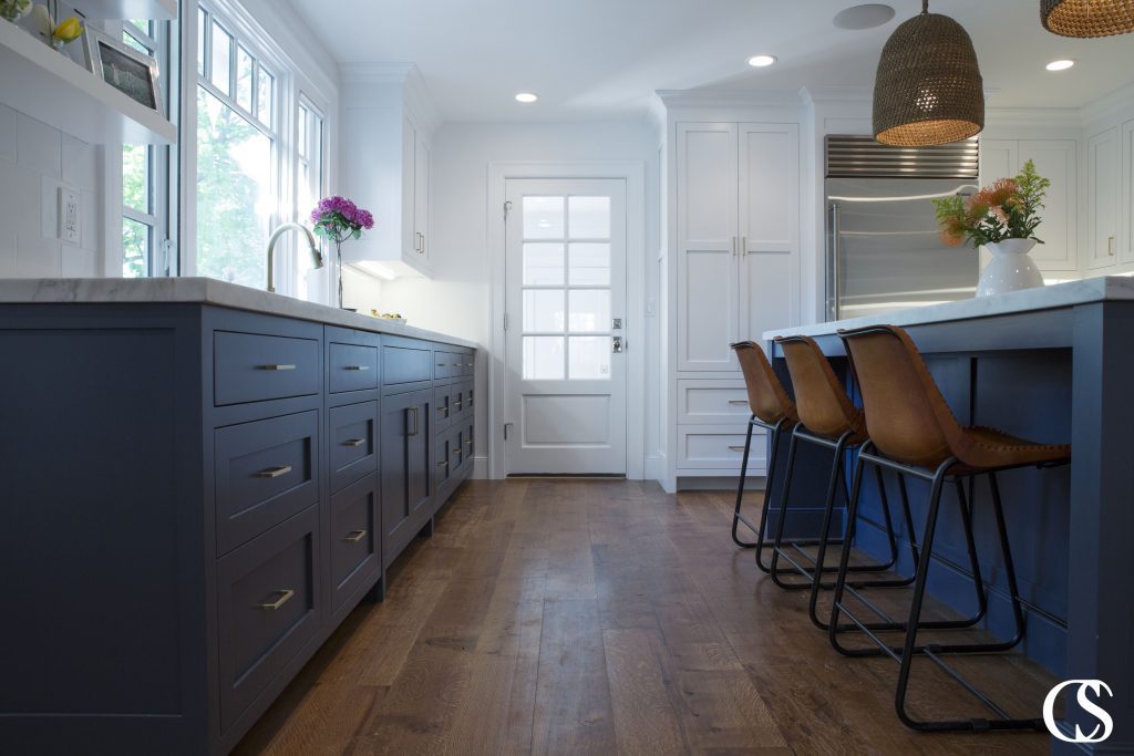 Blue kitchens are popular for a reason! Hale Navy helps these custom kitchen cabinets play perfectly with the white walls and upper cabinetry as well as the warmer tones found in the floor and chairs.