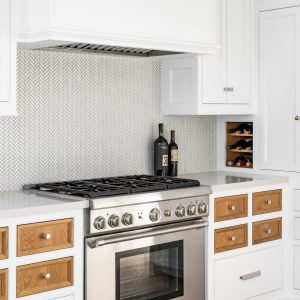 Who says every drawer and cupboard door have to match? This custom kitchen cabinet design features contrasting stained wood against the rest of the white painted cabinets, to great effect!