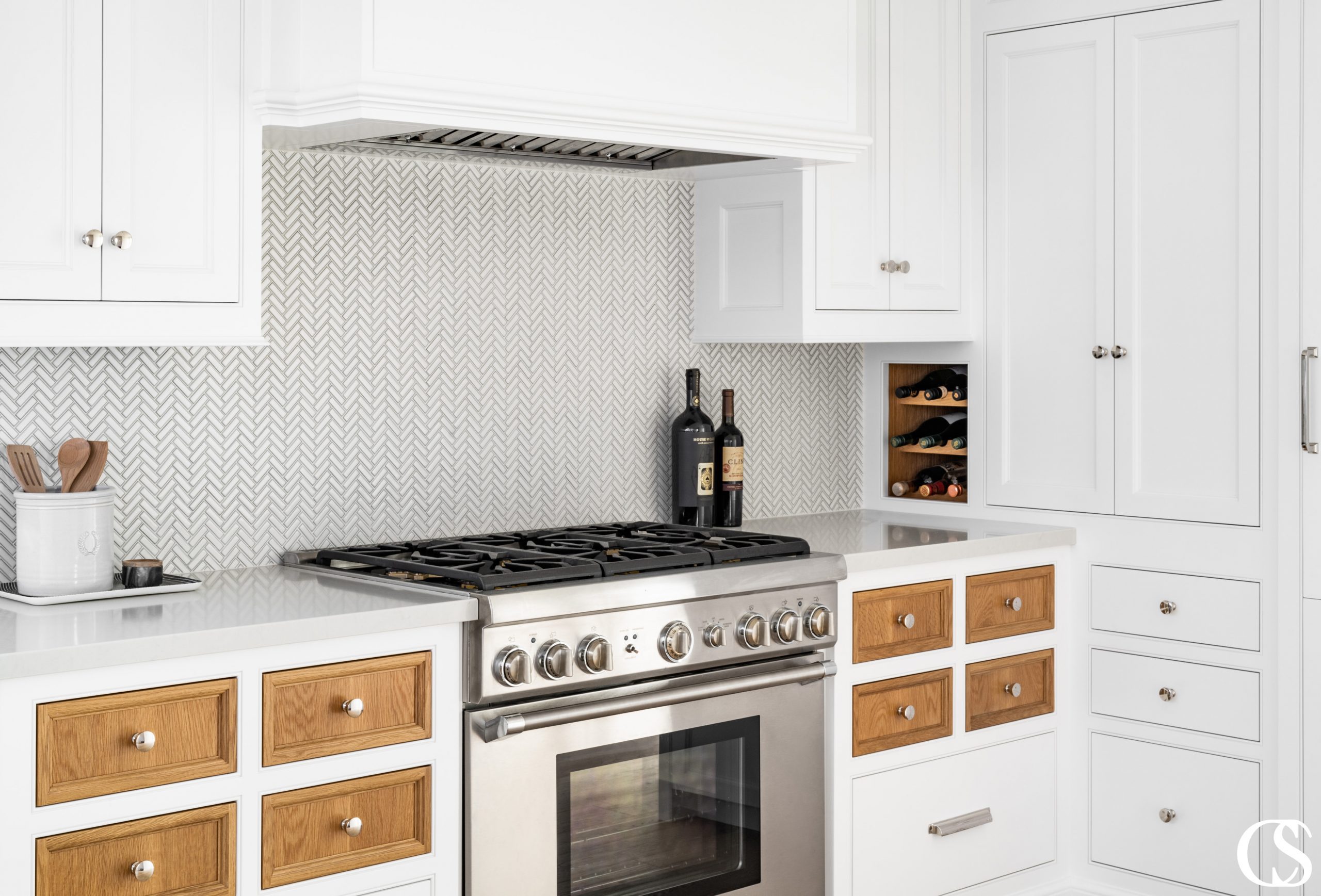 Who says every drawer and cupboard door have to match? This custom kitchen cabinet design features contrasting stained wood against the rest of the white painted cabinets, to great effect!