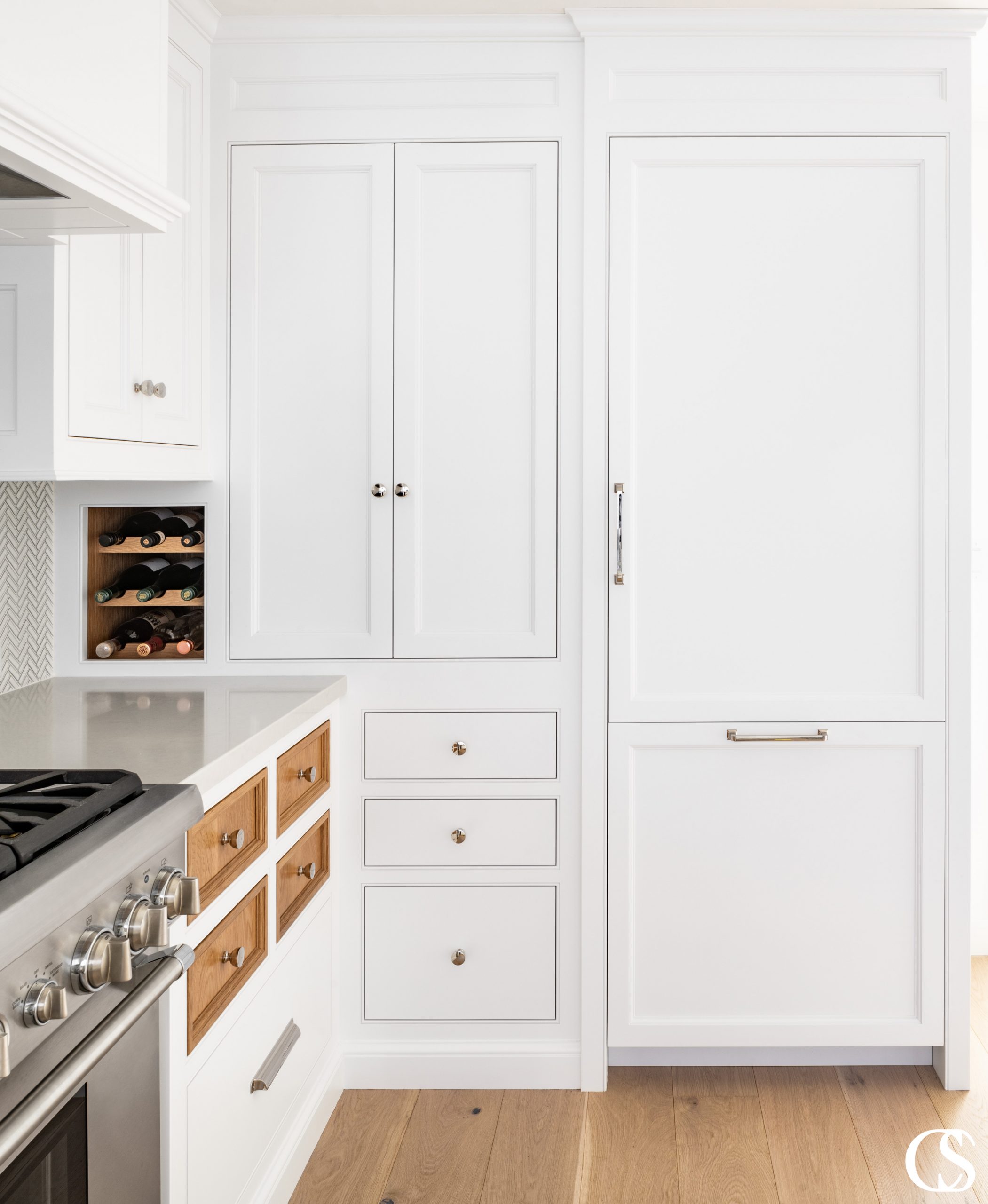 Who says every drawer and cupboard door have to match? These custom kitchen cabinet doors feature contrasting stained wood against the rest of the white painted cabinets, to great effect!