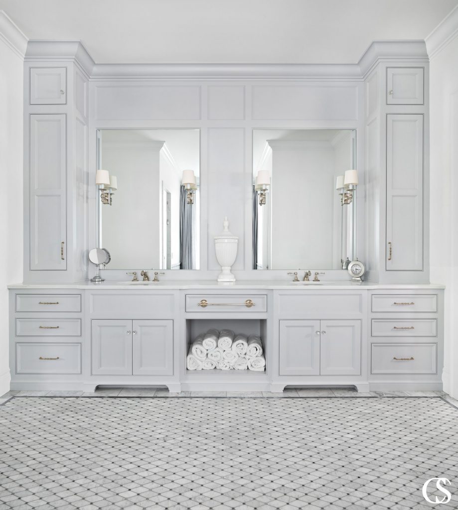 This bathroom vanity is monochromatic, but it uses a combination of drawers and doors, along with unique hardware and intricate molding details to make it feel elegant without distracting from the tranquility of the space