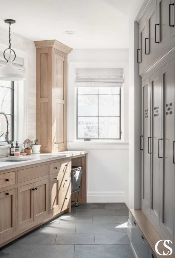 Custom designed mudroom cabinets that provide ample storage and organization options, featuring a mix of open shelving, closed storage, and hooks for hanging coats and bags. The cabinetry is crafted with a durable finish to withstand heavy use and the overall design is functional and stylish, making it perfect for a busy family's needs