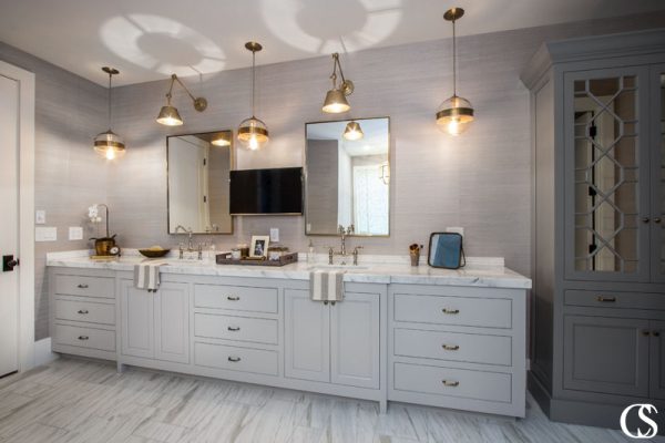 Balancing out popular greige with a deeper color on another cabinet increases dimension and character in any cabinet design—like these unique bathroom cabinets.