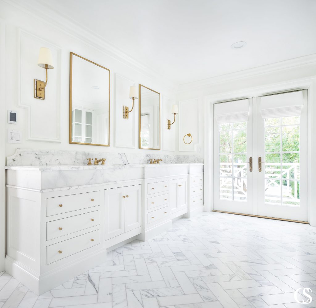 White inset cabinetry with white marble countertops, white herringbone floors, and white paint ensure that this white custom bathroom design excludes luxury.