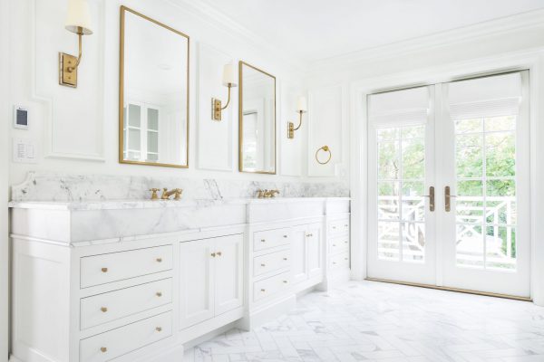 White inset cabinetry with white marble countertops, white herringbone floors, and white paint ensure that this white custom bathroom design excludes luxury.