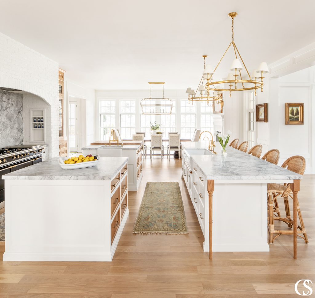 This white kitchen cabinet design is ridiculously unique. We're talking three—yes, THREE—islands, each of which works extremely hard for its square footage.