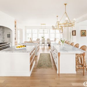 This white kitchen cabinet design is ridiculously unique. We're talking three—yes, THREE—islands, each of which works extremely hard for its square footage.